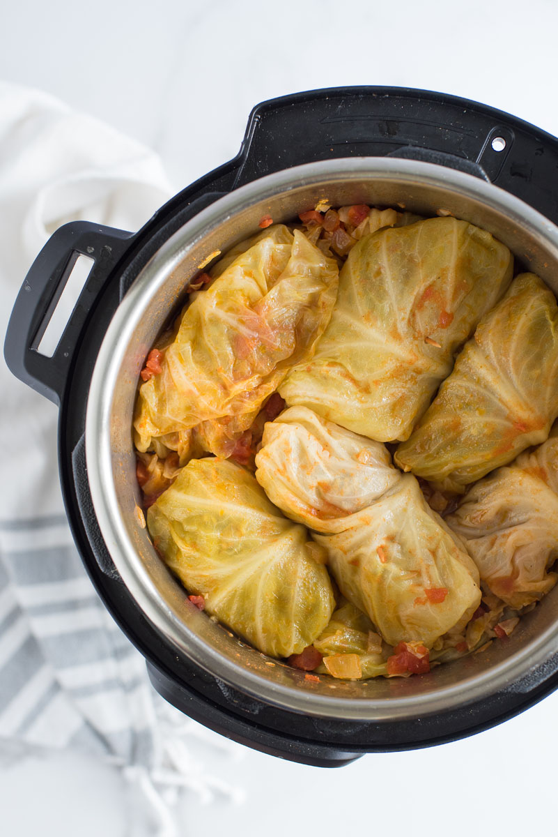 overhead of cooked stuffed cabbage rolls with tomato sauce
