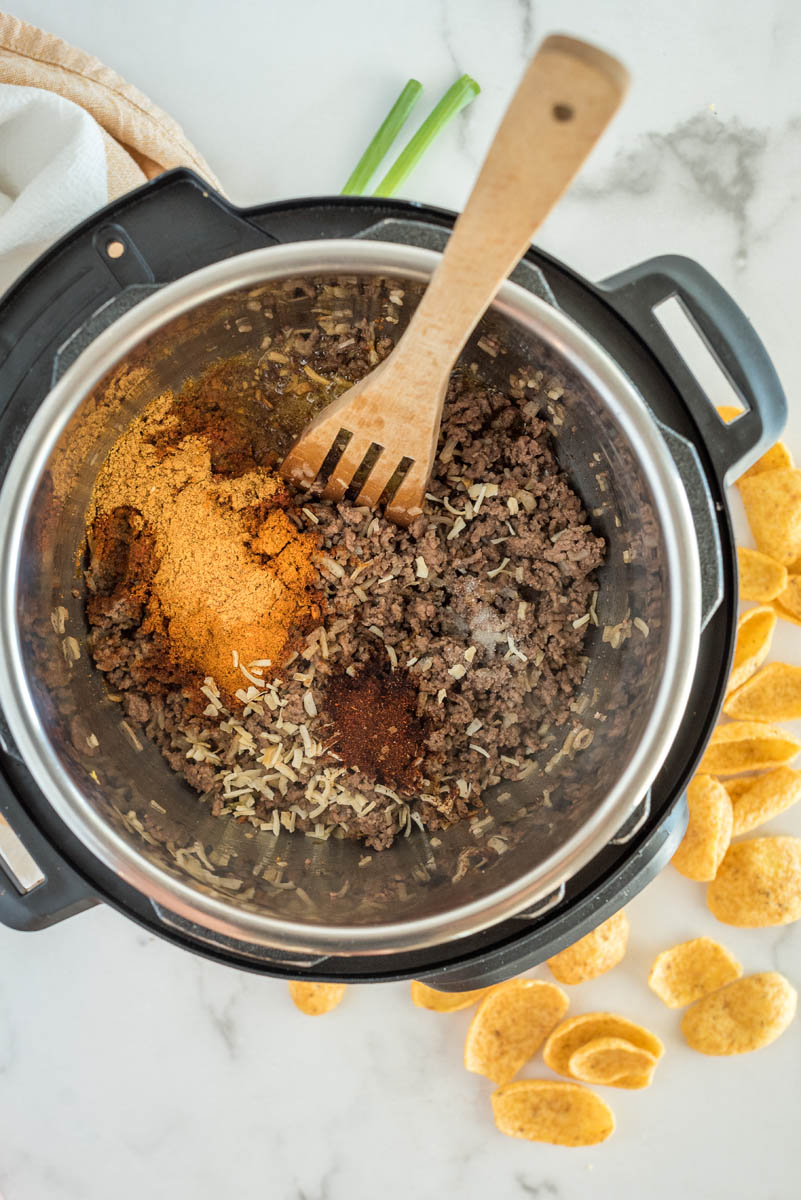 Browning beef and adding taco seasoning to an Instant Pot for taco soup.