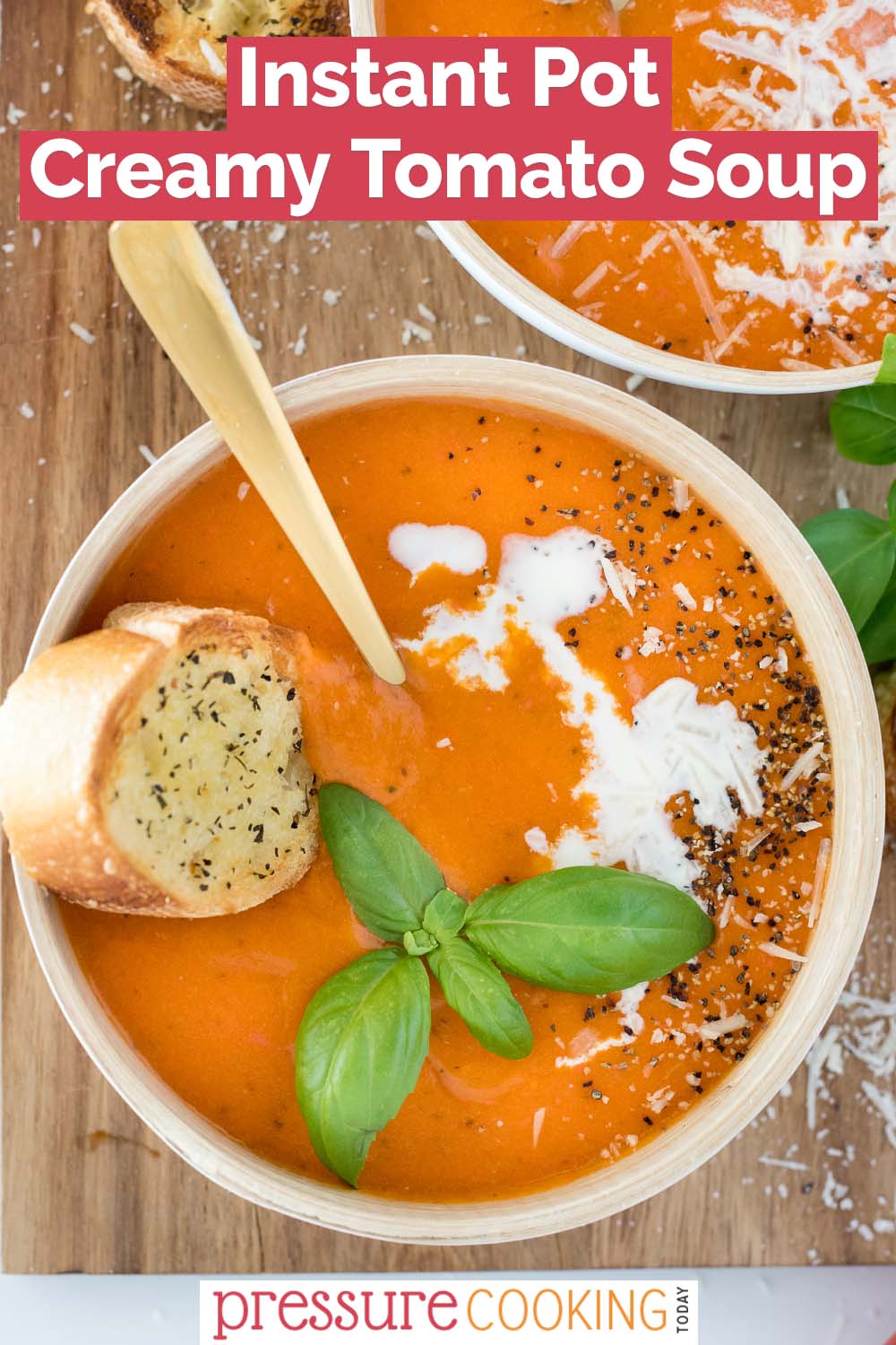 pinterest button promoting Instant Pot Creamy Tomato Soup, with an overhead shot into a white bowl against a wooden background, filled with creamy orange soup, a baguette slice, and a basil garnish via @PressureCook2da