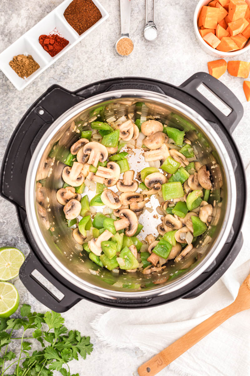 an overhead shot of the Instant Pot filled with green peppers and mushrooms to saute