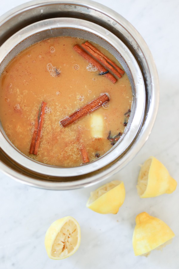 Instant Pot wassail being strained after cooking