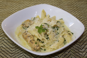 spinach-artichoke-pasta-with-chicken in a white bowl